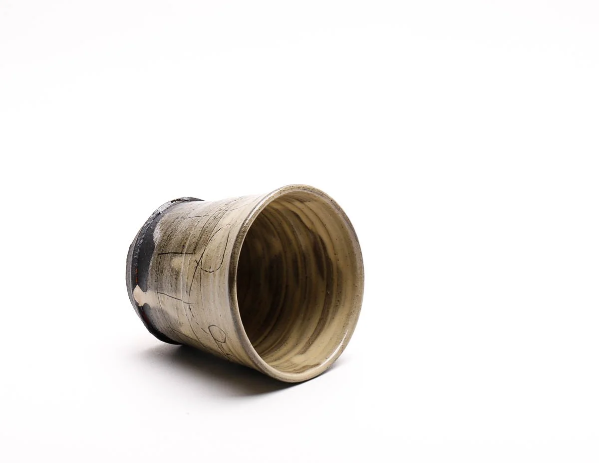 Earthenware beaker with dripped yellow glaze effect and dark features