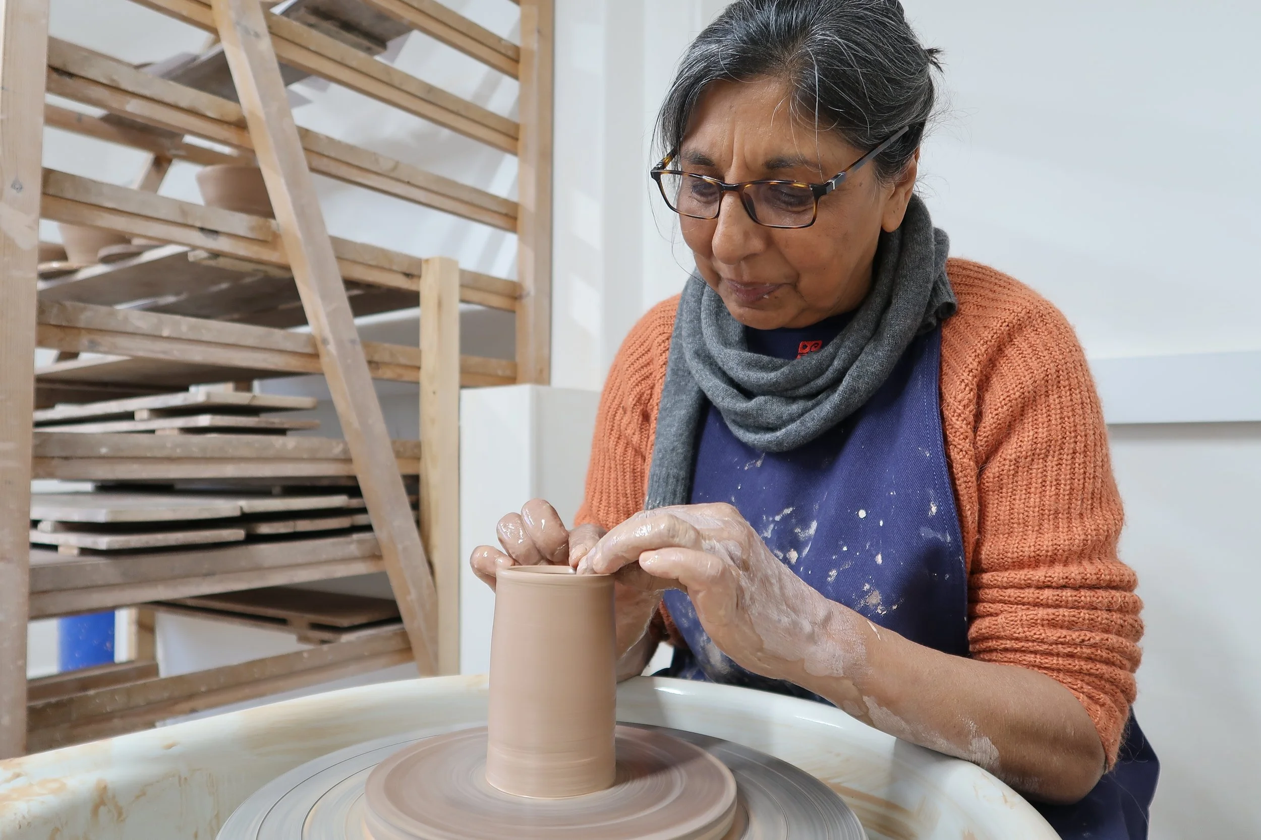 Potter setting the rim of a cylinder