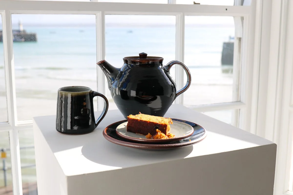 Large teapot made at the Leach Pottery in tenmuko (deep black) glaze with Standard Ware mug and side plate