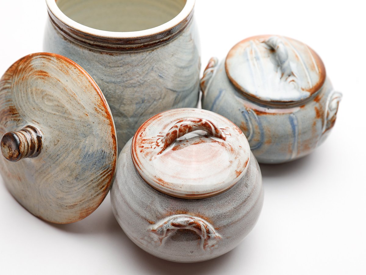 Small trinket box with twisted detailed handle, in a  creamy white glaze with orange details