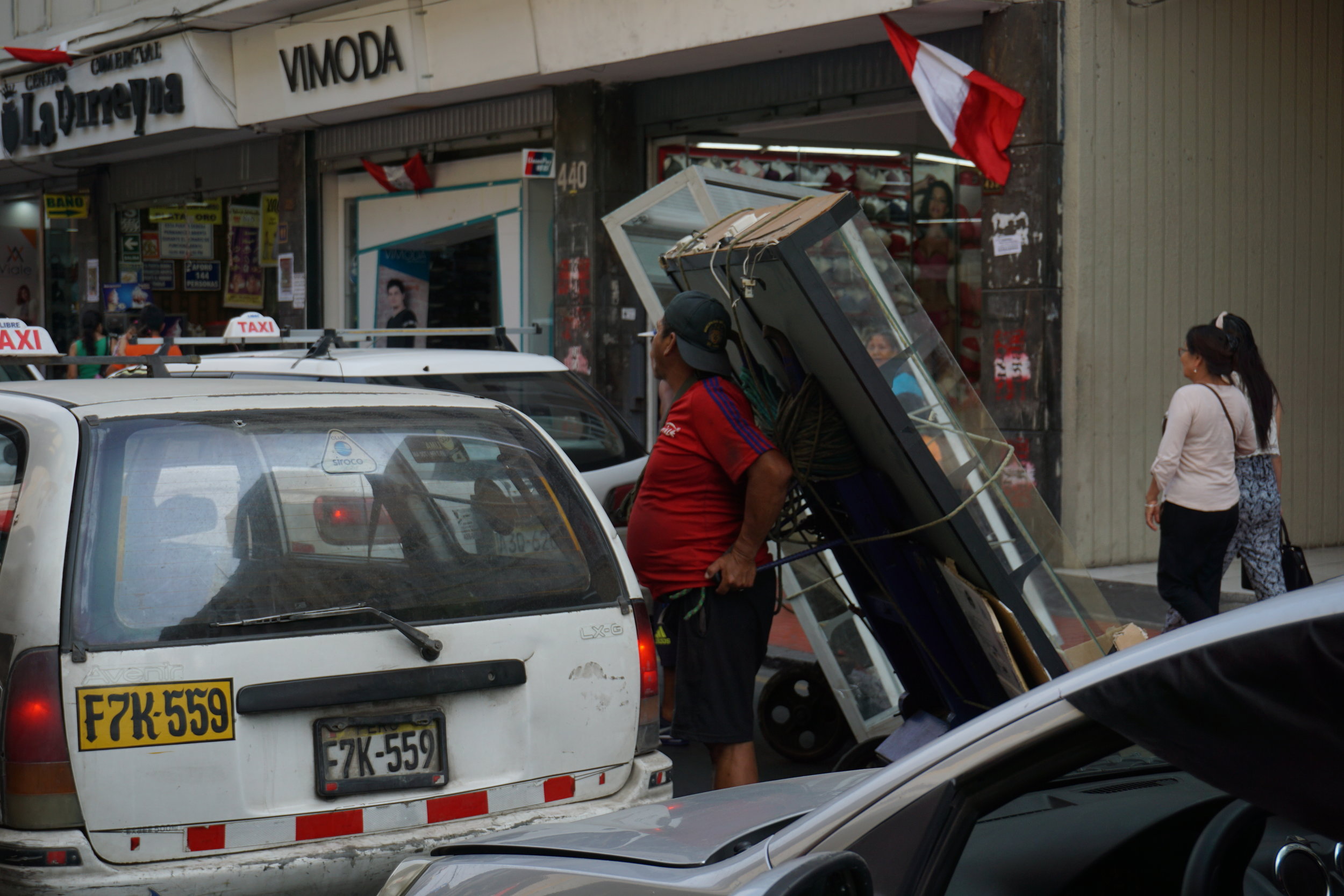  Manual delivery of a wide parcel requires sharing the street with cars where sidewalks are narrow and crowded. 