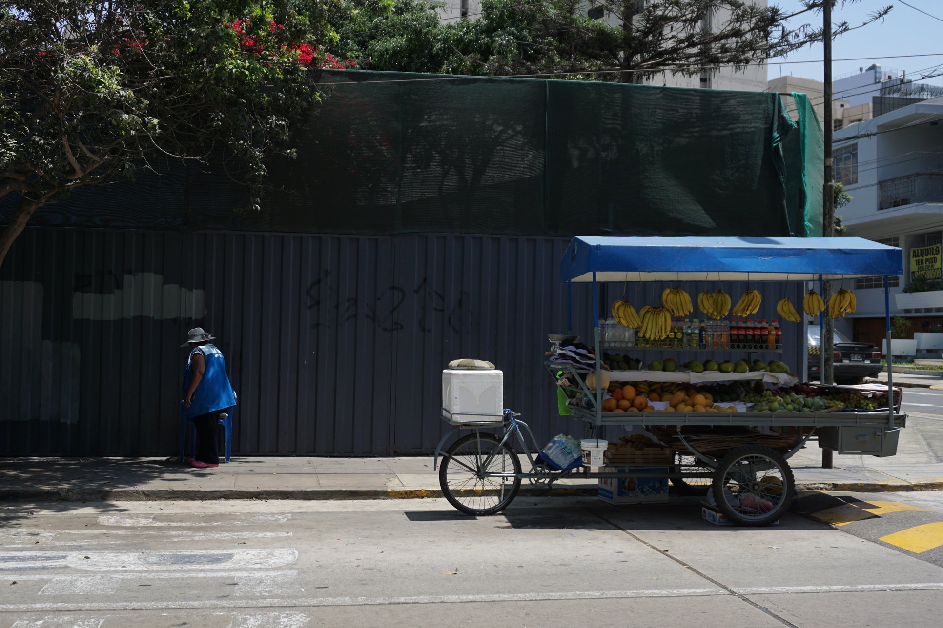  A fruit vendor finding a shaded spot to sit on a hot day in Lima's Miraflores district. 