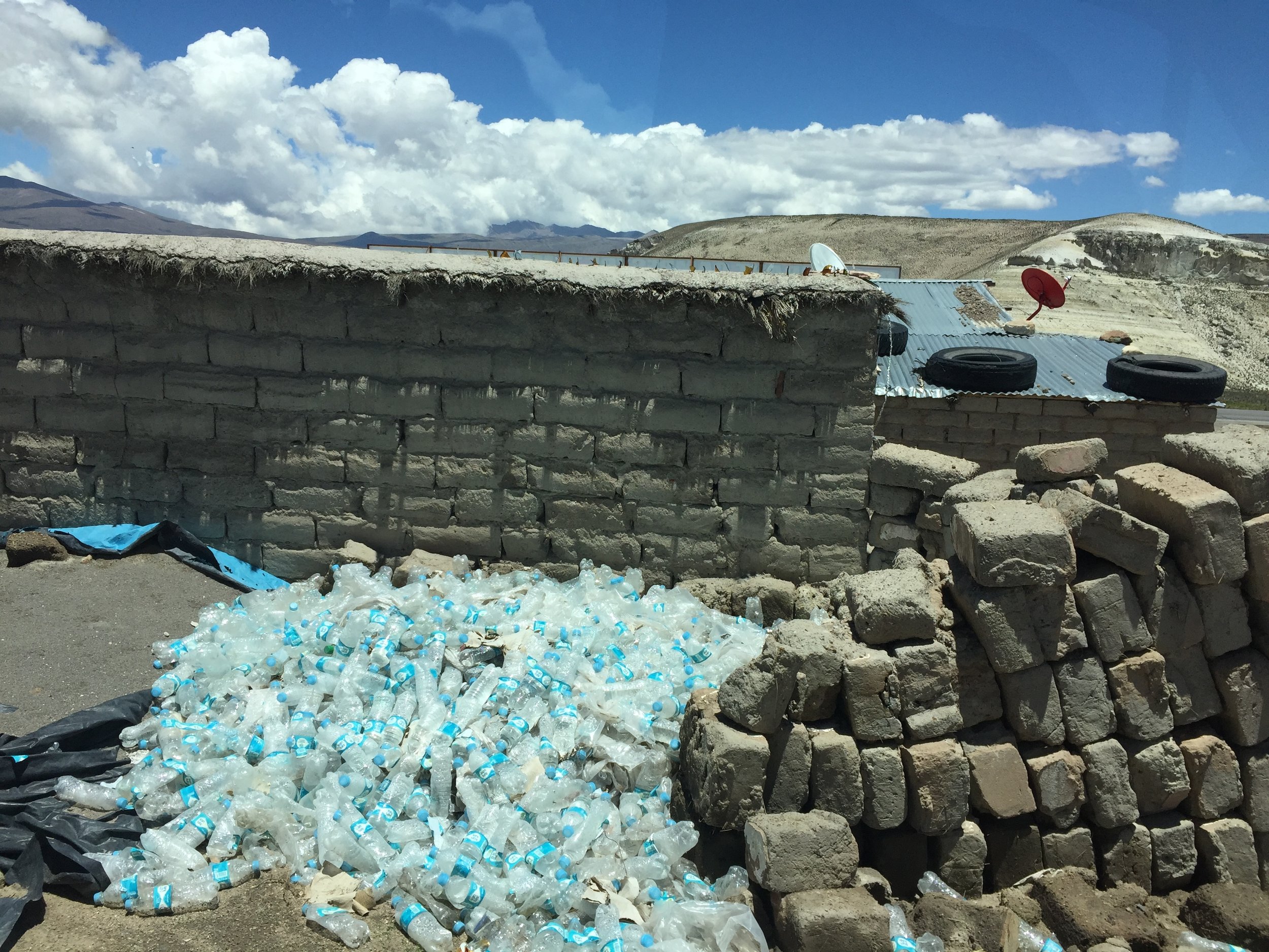  Municipal water supplies are not to be trusted in Peru; bottled water is the way to go to prevent illness. Unfortunately, all that waste has to end up somewhere (here in the back of house in the altiplano, miles from anywhere). 