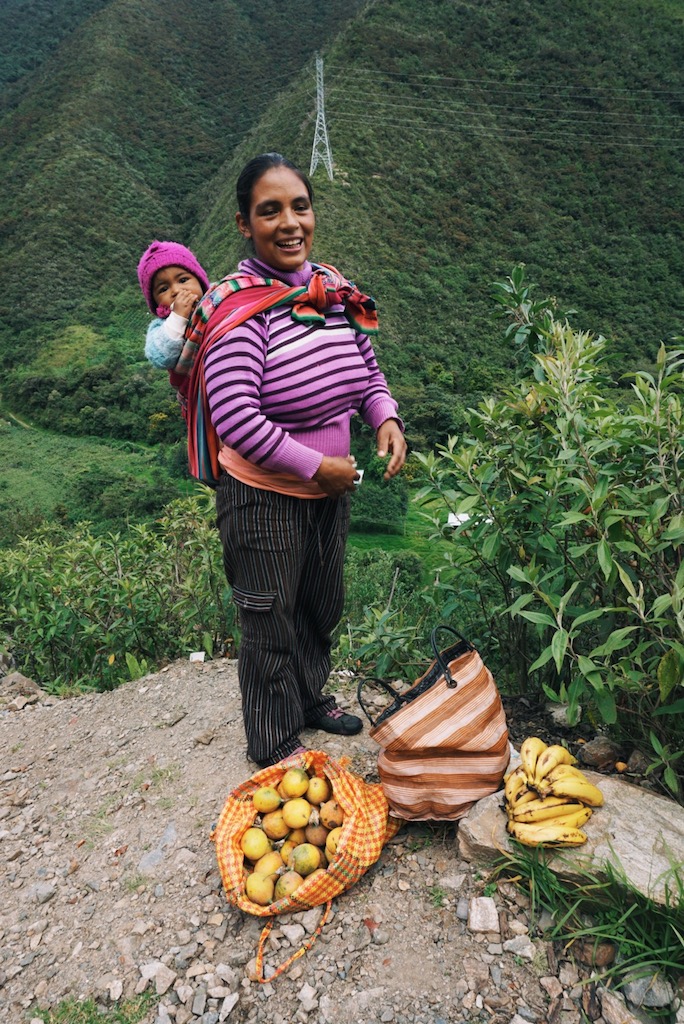  A fruit vendor selling passion fruit and bananas she grows down a steep path and next to the river.&nbsp; 