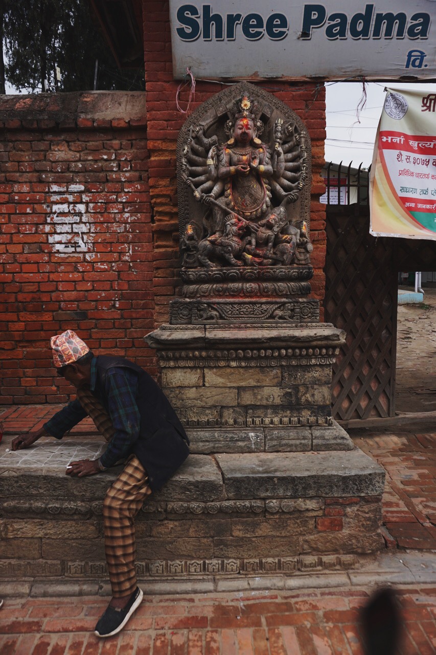  Shiva looks on over a man in a traditional Nepali hat 