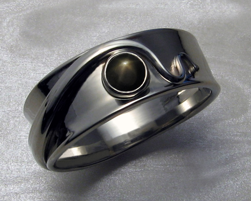 Fluid, organic, freeform gents wedding-ring with black star sapphire.