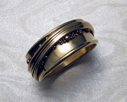 Free-form, wrap-a-round wedding ring with spherical granulation.