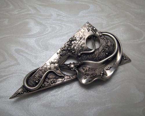 Handcrafted, free-form, triangular brooch with spherical granulation.