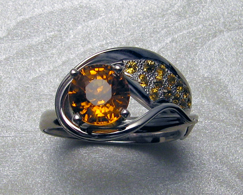 Asymmetrical engagement ring with orange sapphires.