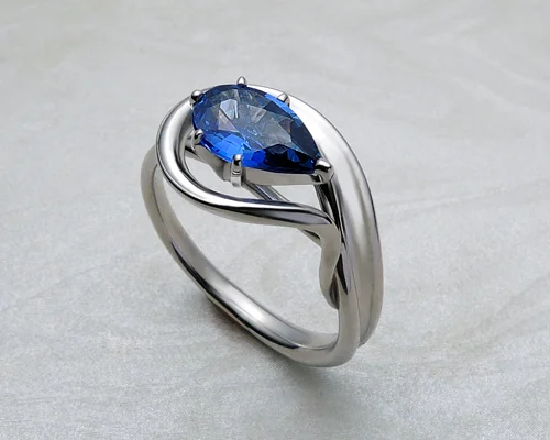 Pear shaped engagement ring with cornflower blue sapphire.
