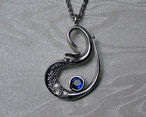 Unique, pendant necklace, with sapphire, bezel set, and diamonds.
