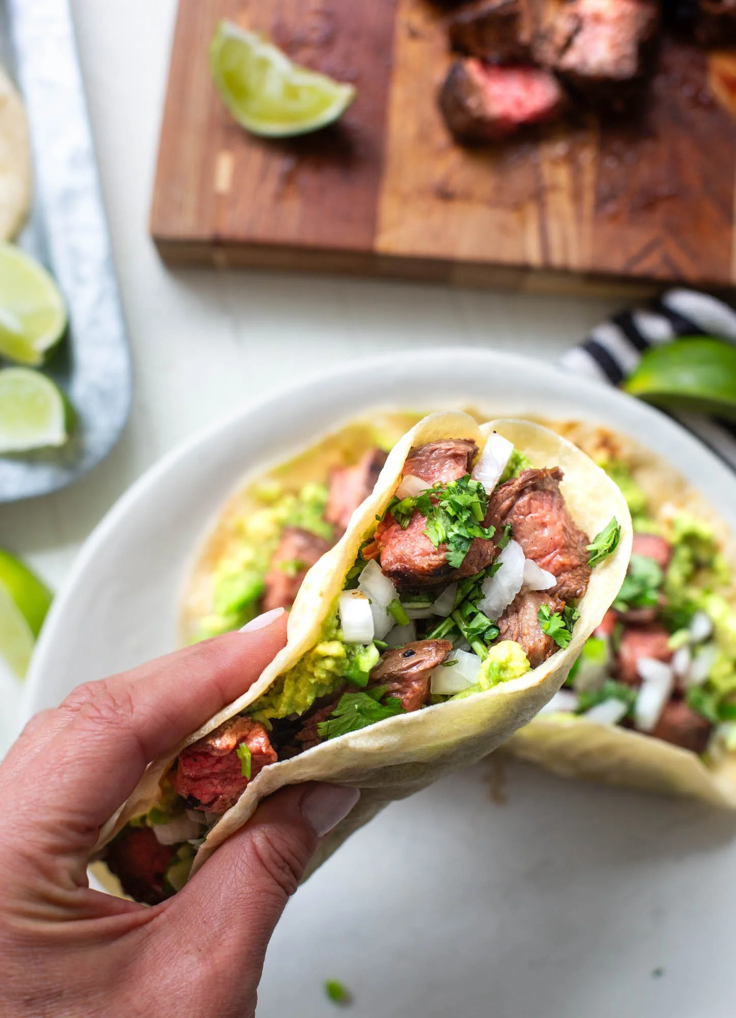 Picking up a carne asada taco in a close up image.