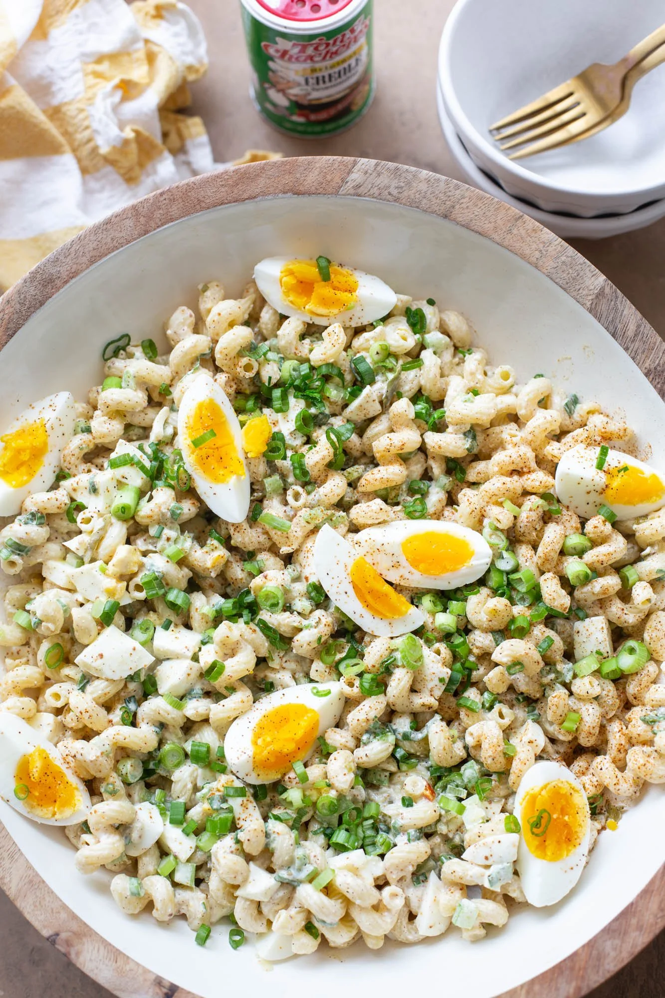 Close up shot of Cajun deviled egg pasta salad with bowls to serve it on the side.