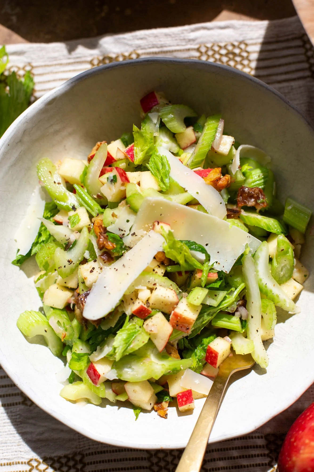 Close up of a celery apple salad being served into a bowl.