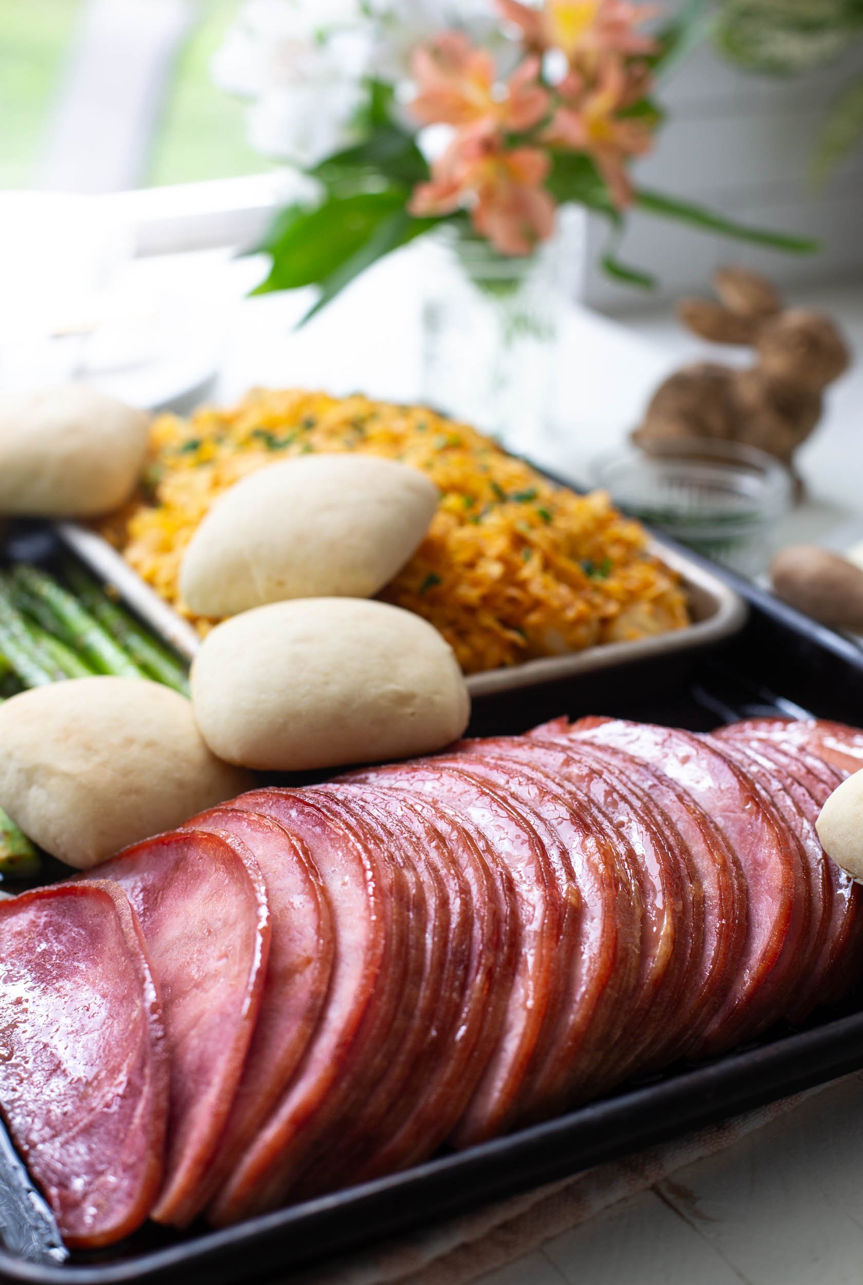 Sheet pan Easter dinner with glazed ham, potato casserole, and asparagus.