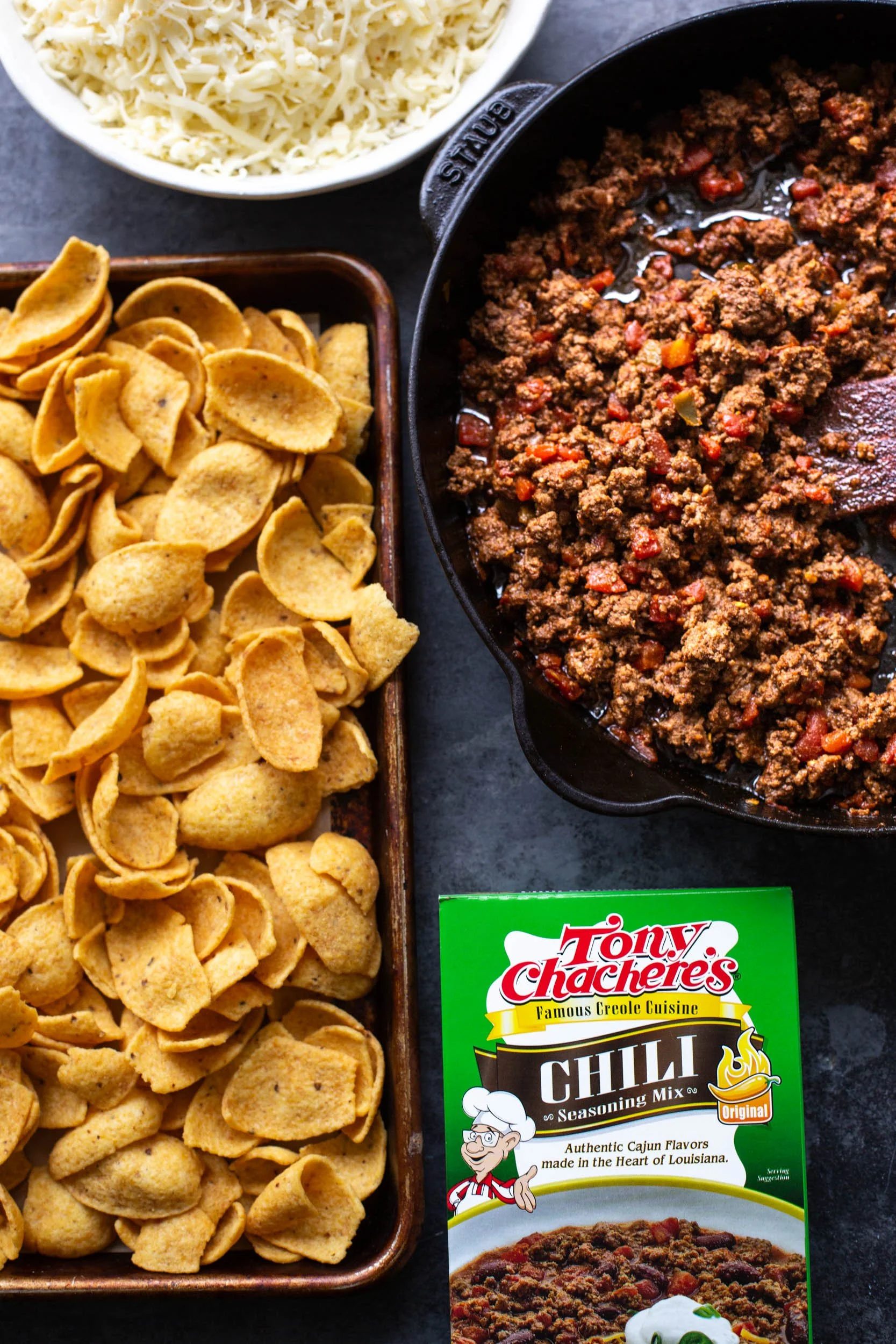 Seasoned ground beef and cheese ready to be layered onto corn chips before baking.