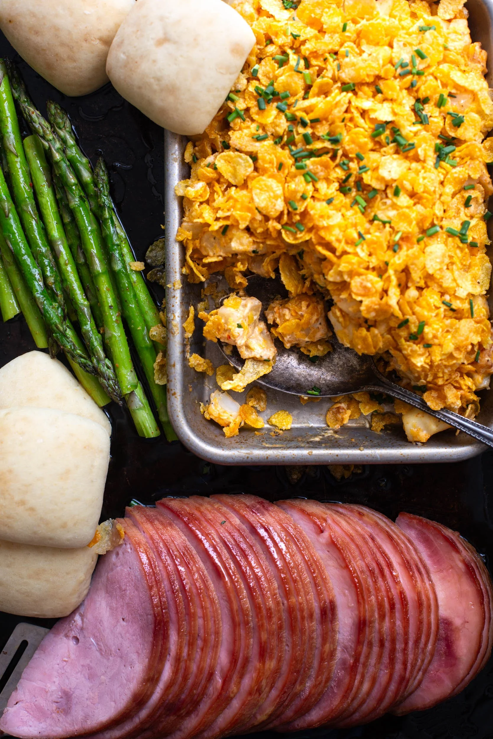 A simple sheet pan Easter dinner featuring ham, potato casserole, and asparagus.
