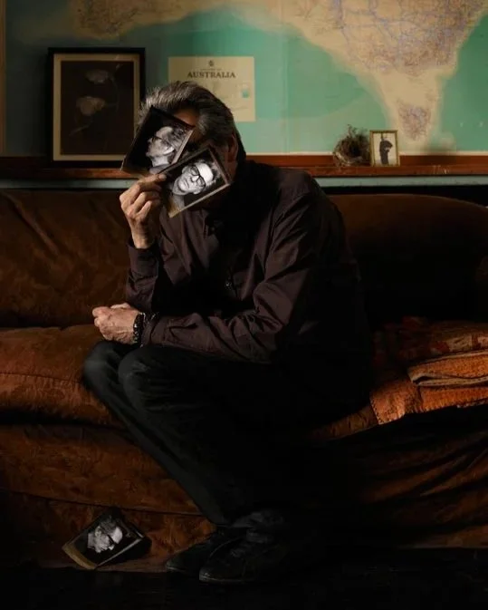 Self portrait of Gary Heery in living room in front of a map of Australia