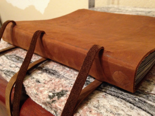 10 :The book and the leather cover are combined, the leather cover is cut and the leather straps are pulled through.