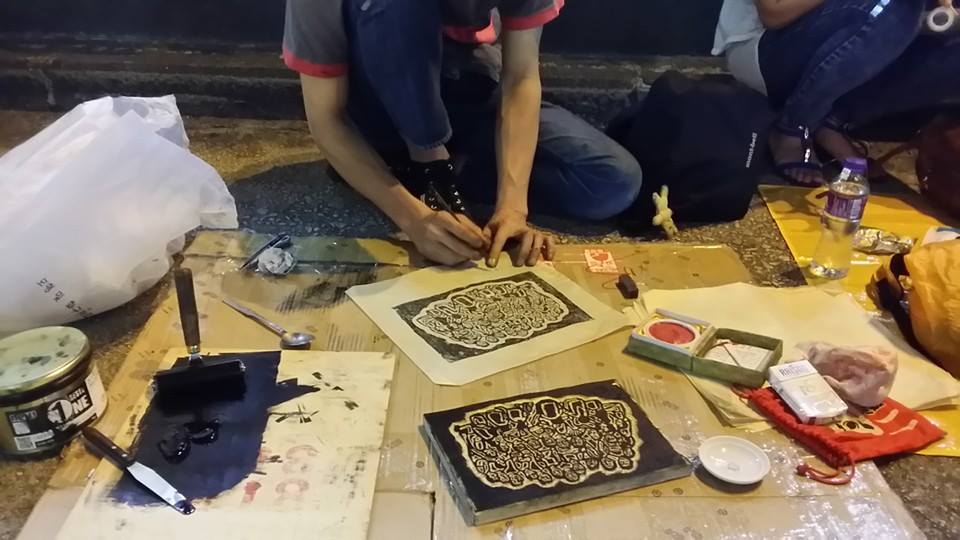 香港オキュパイの路上で版画を彫る