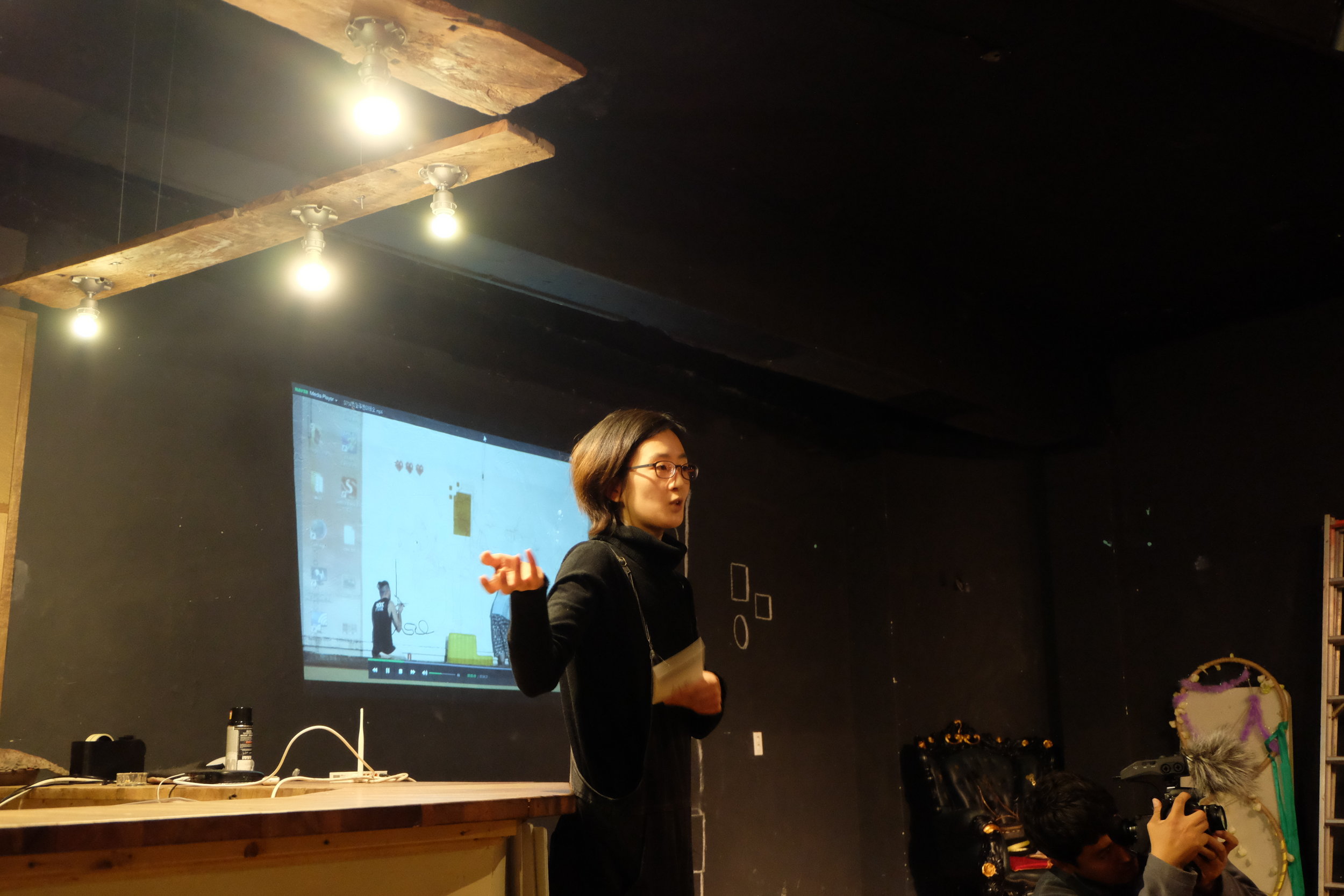 コミュニティーに根付いたストリートアート的活動について説明中。