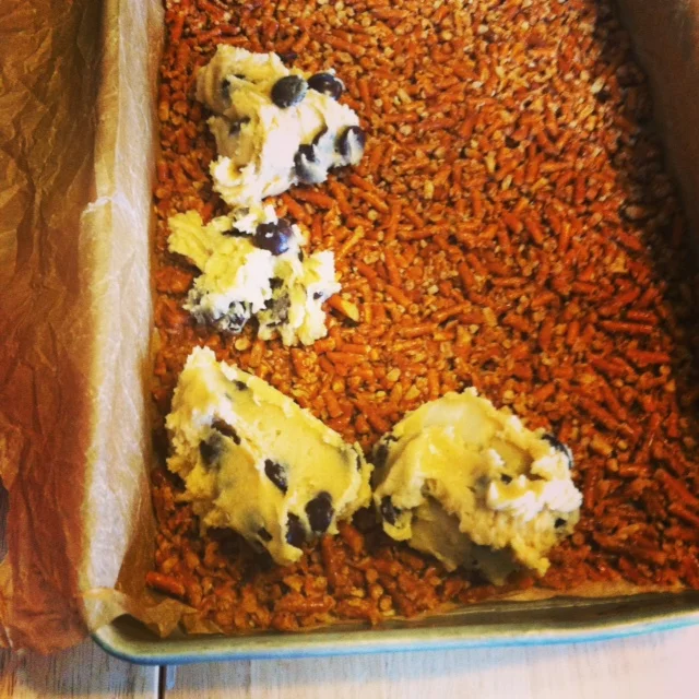 Drop spoonfuls of the cookie dough evenly across the pretzel crust.