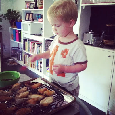 Saucing the wings with the best sous chef EVER.&nbsp;