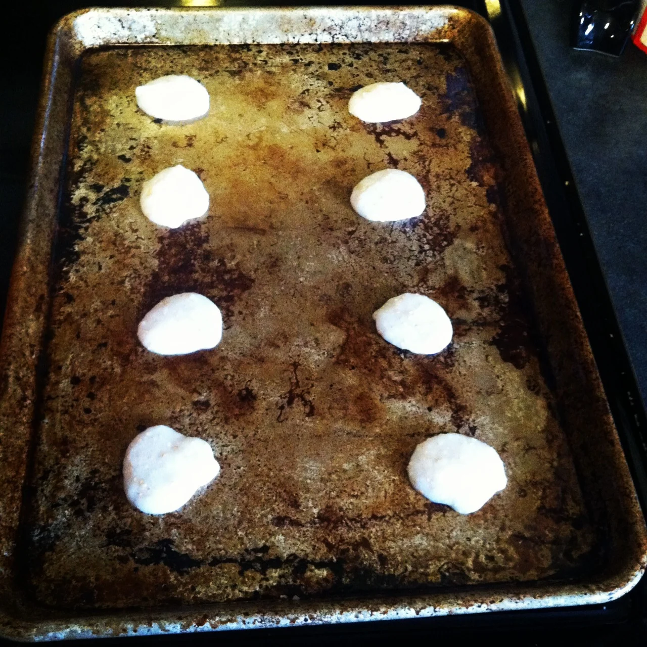 Spooning the cracker mixture onto my well-used sheet pan.&nbsp;