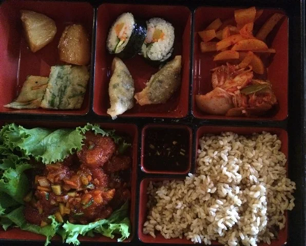My lunch box with shrimp in a garlic sauce, rice and chef selected sides.
