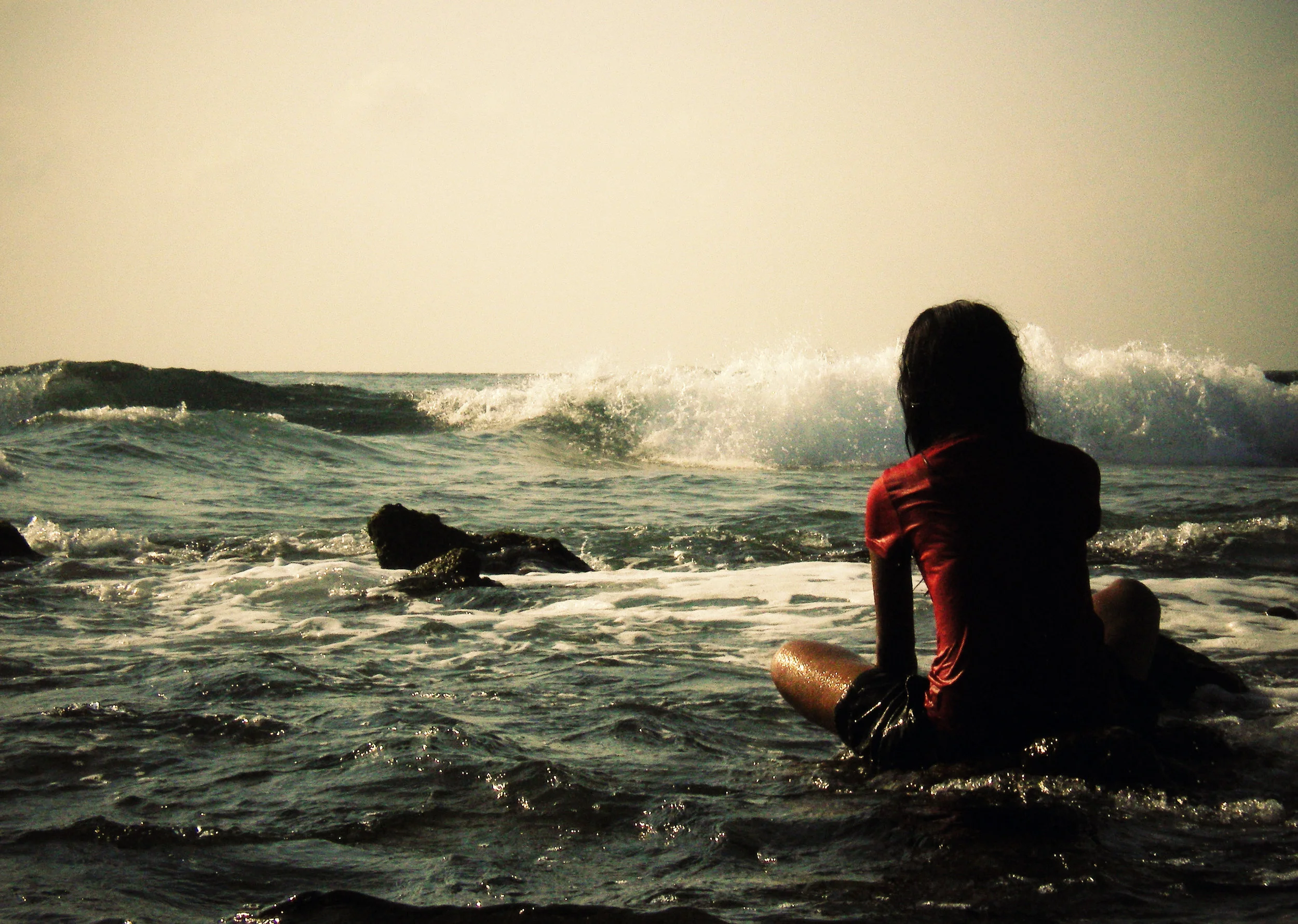 Young woman meditates while sitting on a rock at the shallower side of Raalhugandu. Raalhugandu Henveiru ward Pentax Optio M30 (2008)