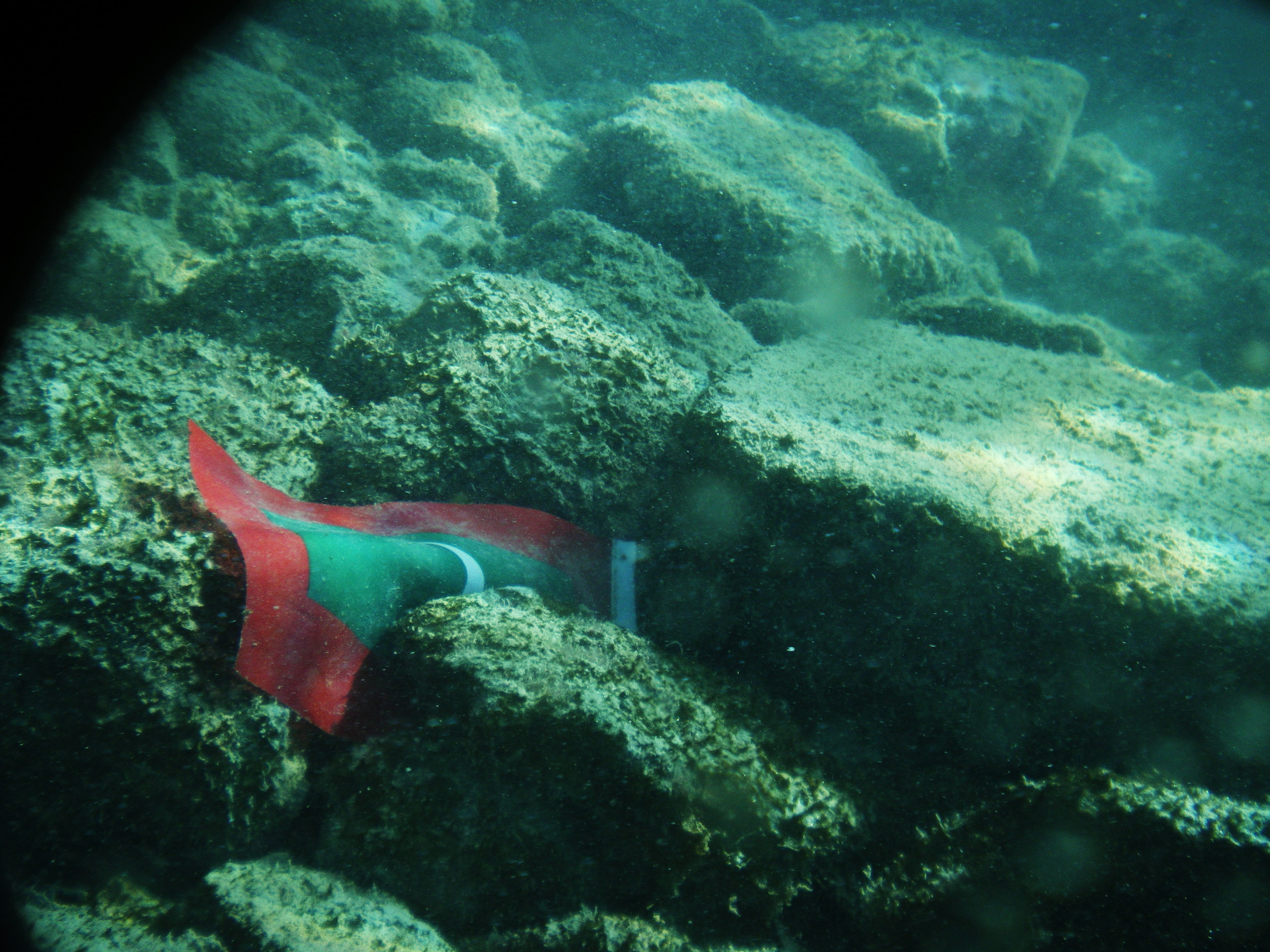 A small Maldivian flag lays discarded at the bottom of the track. Pentax Optio M30 (2007)