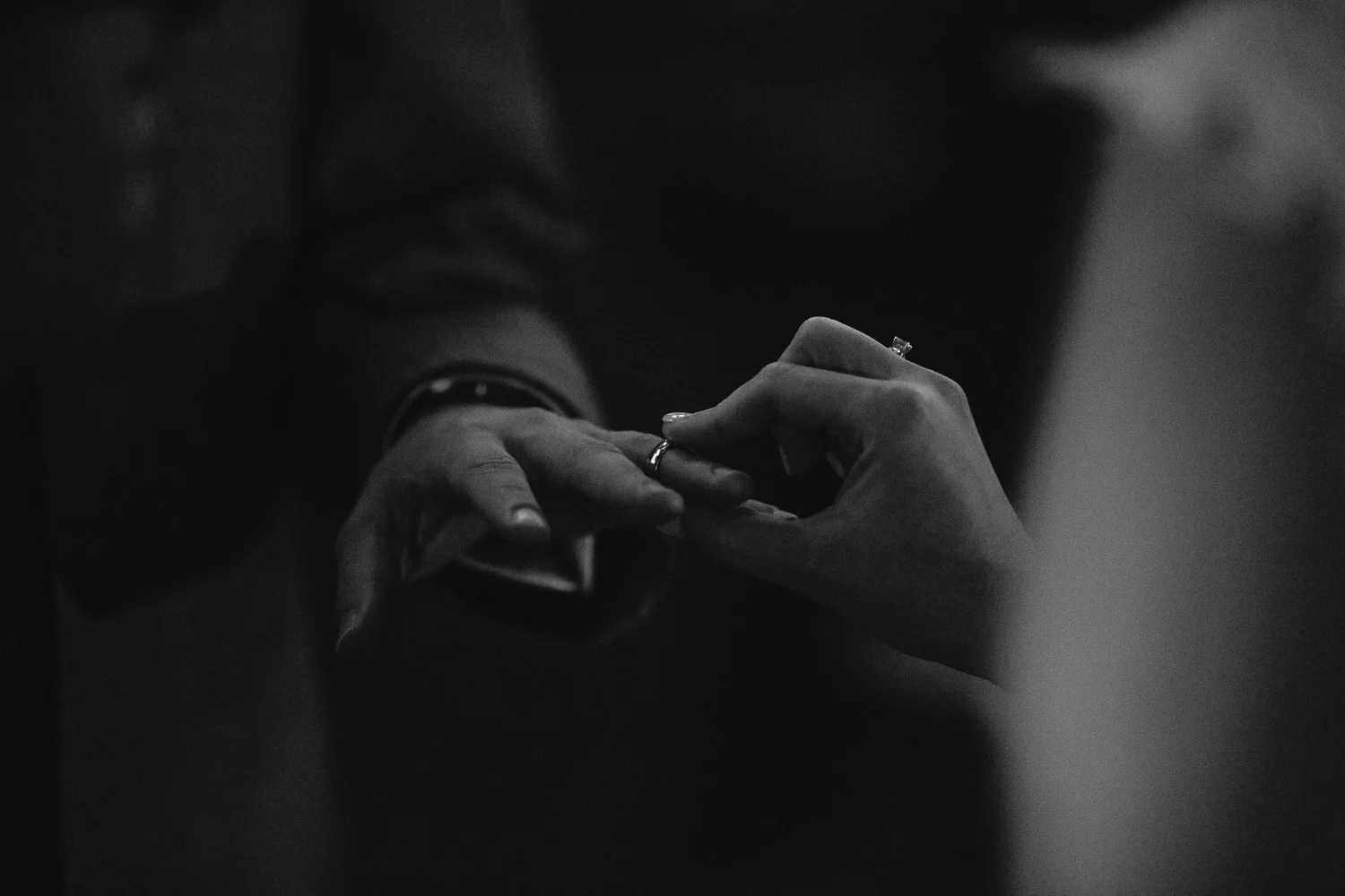 Wedding ring being placed on groom's finger at a nighttime ceremony at Highland Manor in Orlando