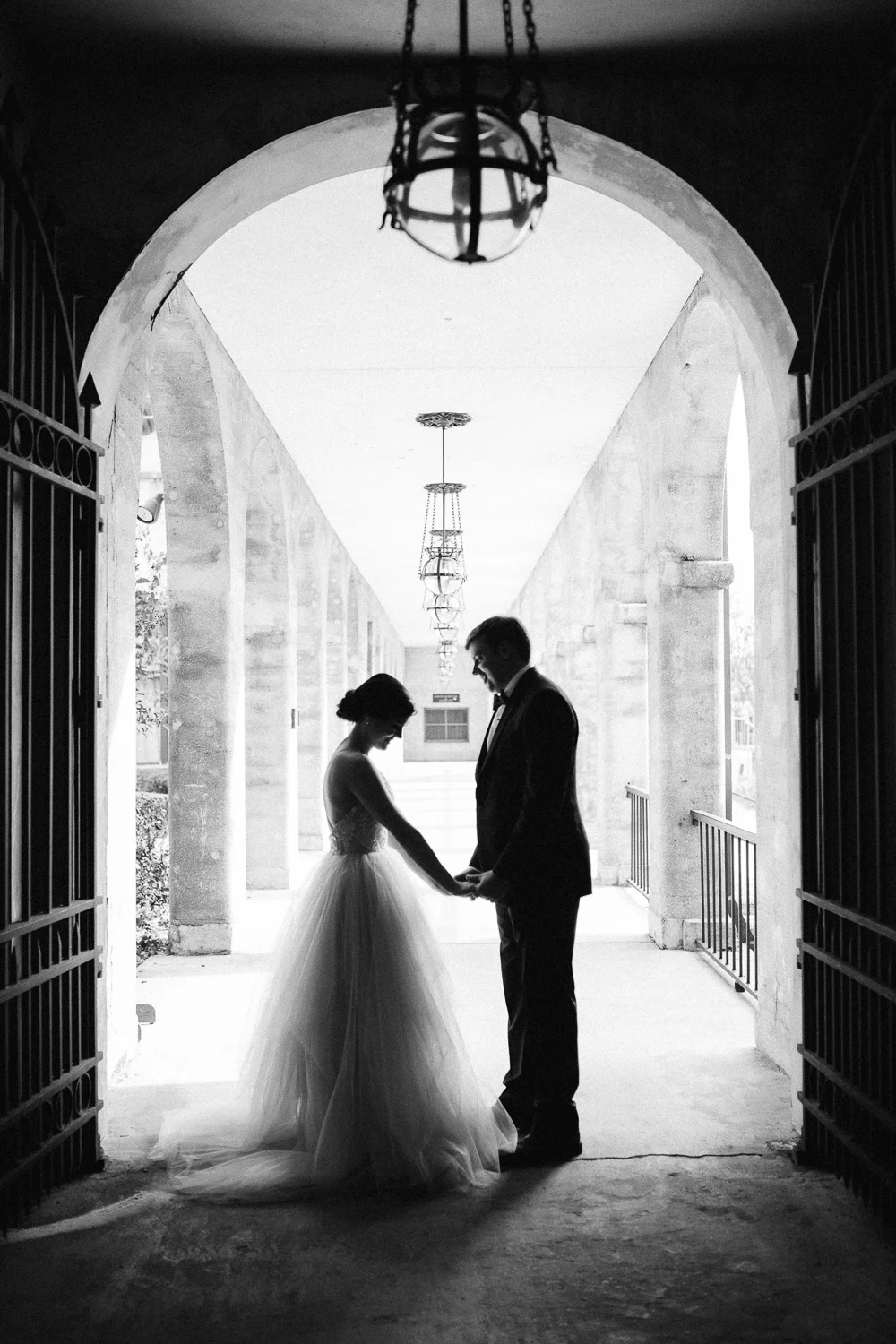 Bride and groom silhouetted in an archway at Lightner Museum gardens in Saint Augustine Florida