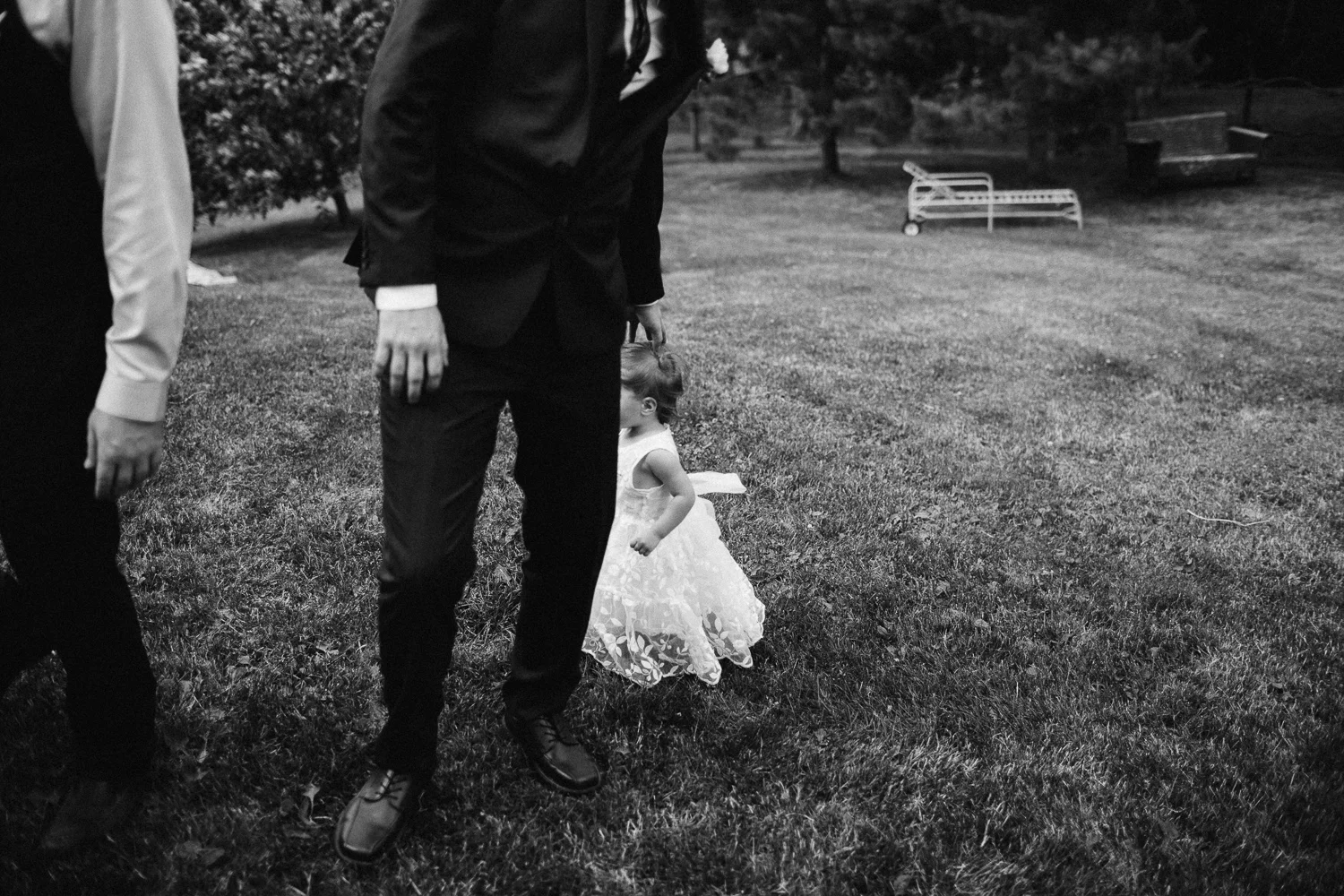 Groomsman gives the flower girl a pat on the head at an outdoor farmhouse wedding at Blue Horse Farm in Wisconsin