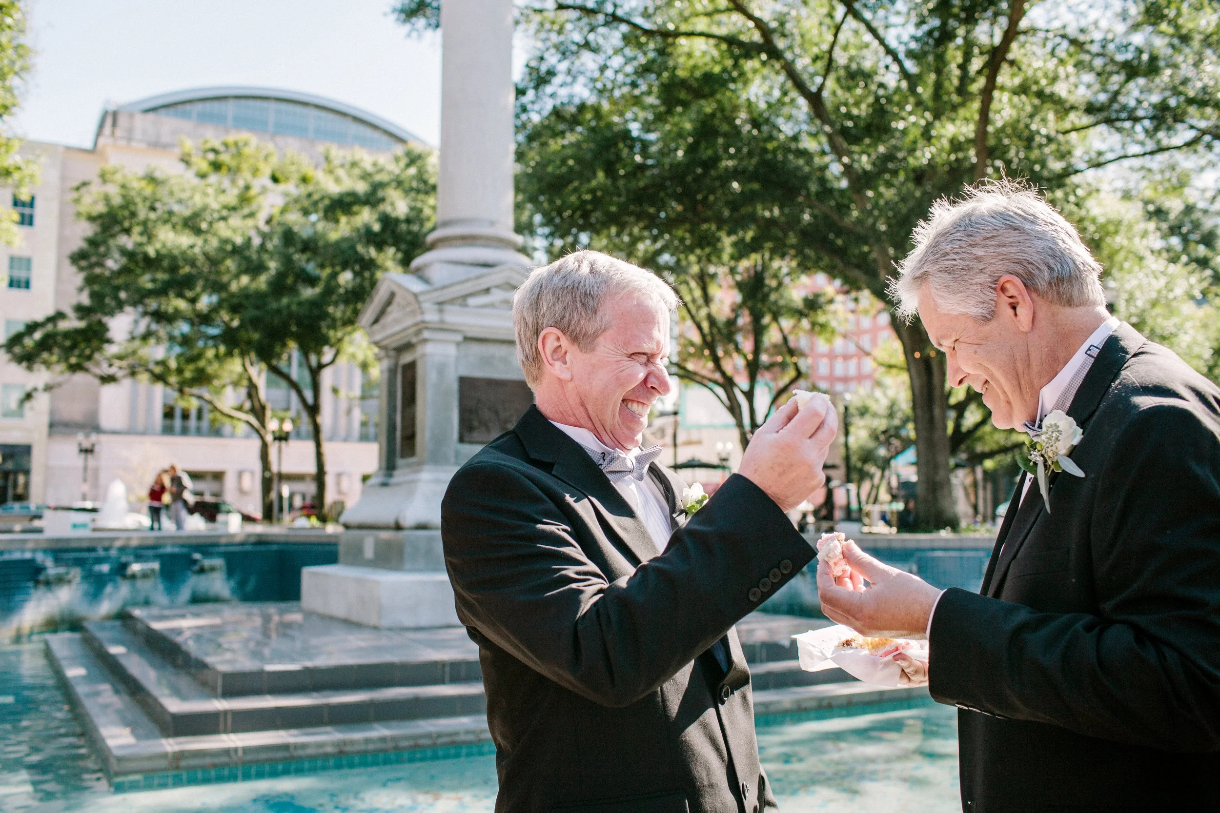 Two newlywed grooms share cake at their same sex wedding in Hemming Park Jacksonville