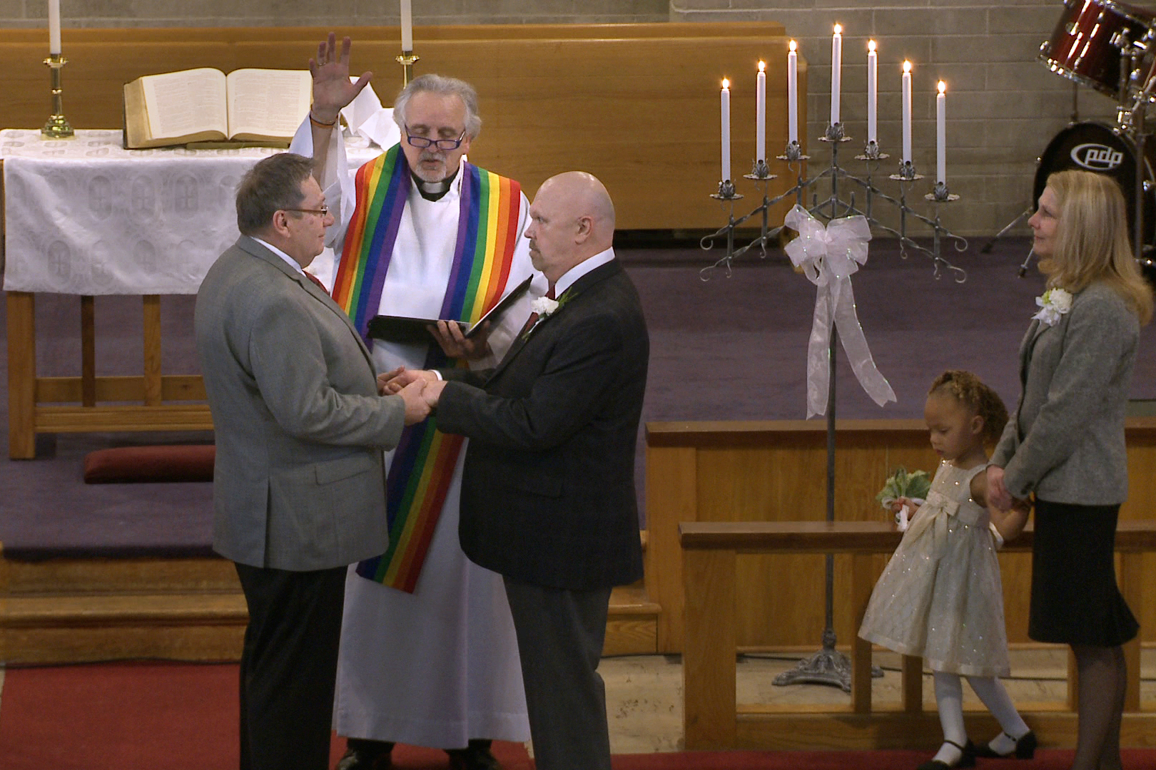 The Rev. Gordon Hutchins marries Wayne and Michael Simonson in their church, in defiance of current United Methodist Church law.