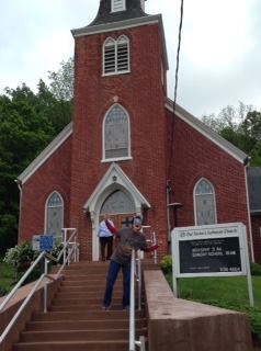 Parishioner of Our Savior's about to enter worship service wearing glasses in the shape of two red, white and blue electric guitars. "Open my eyes, that I may see...." 
