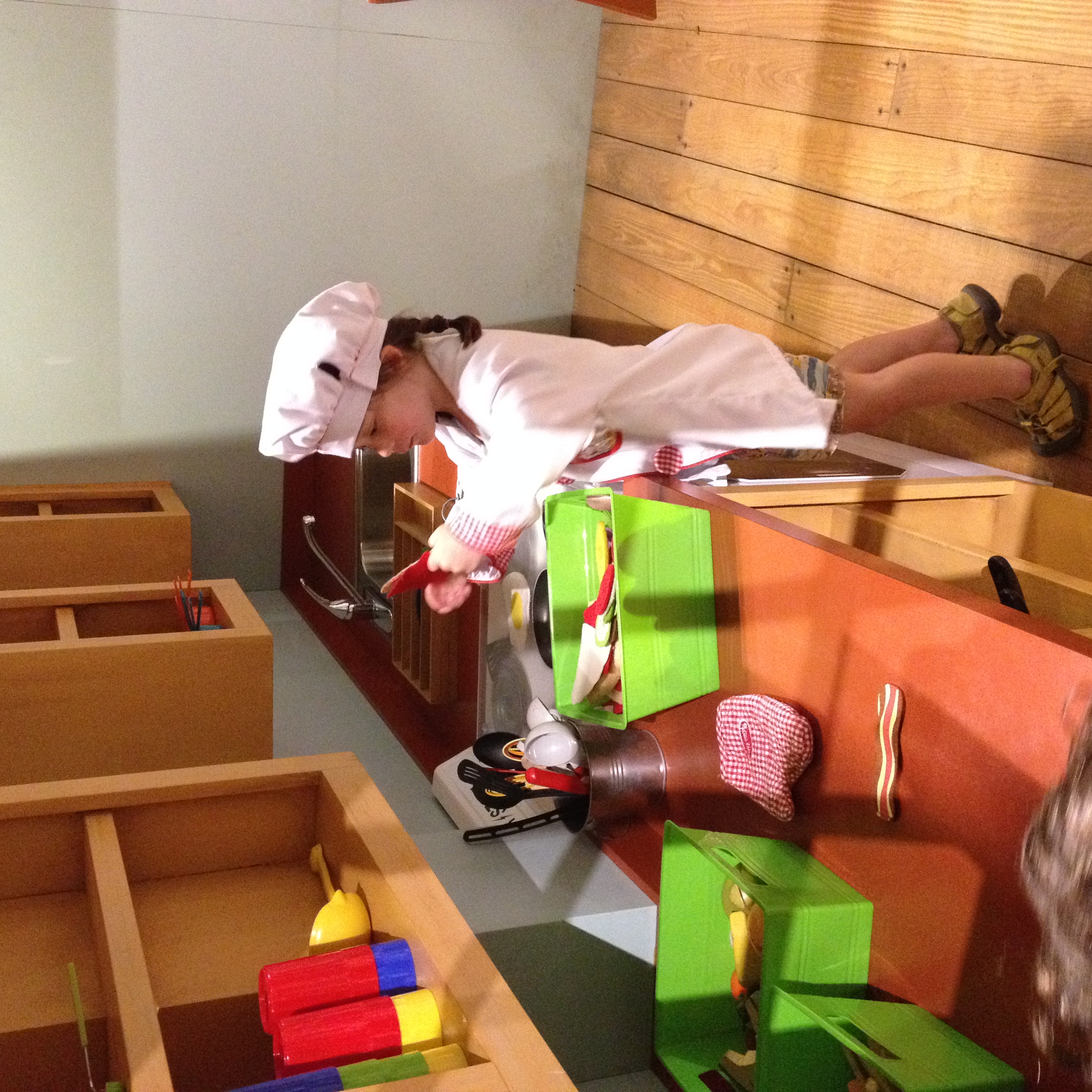 Théa playing chef at the Bayou Children's Museum. She also played doctor, construction worker, knight, fireman, railway conductor, and Batman that day at the museum.