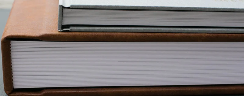 Top - Thin pages. Bottom - Thick pages are 2mm thick. They are a sturdy build that is constructed with a substrate between each page. For think pages add - 12x12 add $250.00, 10x10 add $220.00, 8x8 add $190.00