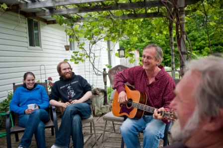 Heidi Tomes, Kieran Jedermann and Doug Dingledein (r) watch Dave Joyce strumm and sing