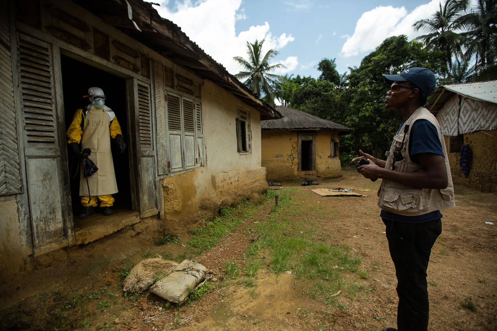  Bong County, Liberia - October 9, 2014: Team leader, Elvis, speaks with a&nbsp;member of the International Medical Corps (IMC)&nbsp;Ebola response team who entered a family home in Mawa Town to check on an elderly woman who became&nbsp;sick after se