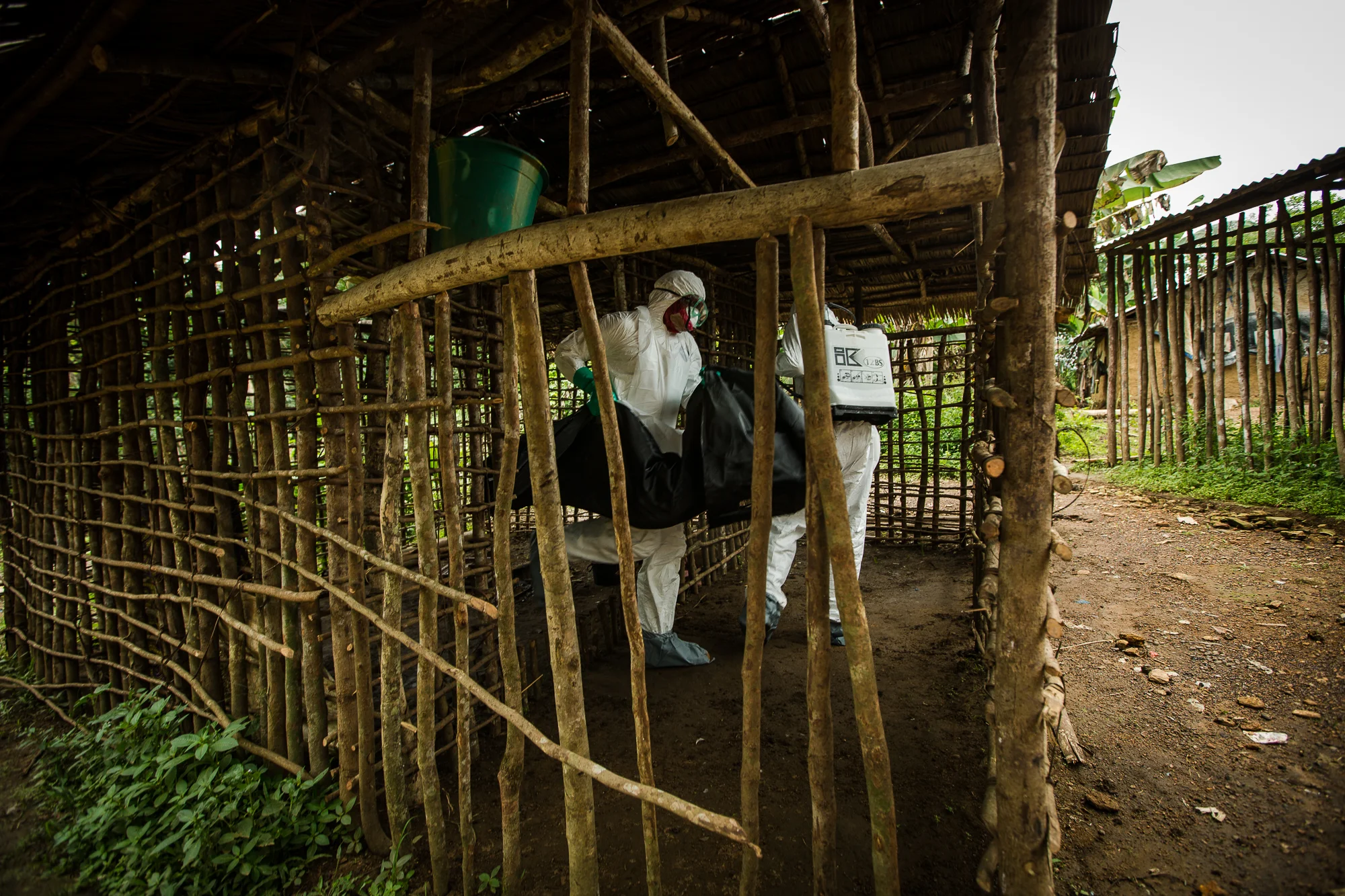  Arthington, Liberia - September 26, 2014: &nbsp;Melvin Payoh, Assistant Team Leader, of a Global Communities burial team&nbsp;removes the body of six year old Phelica Anthony, suspected to have died of Ebola, from her family home. Her father was tak