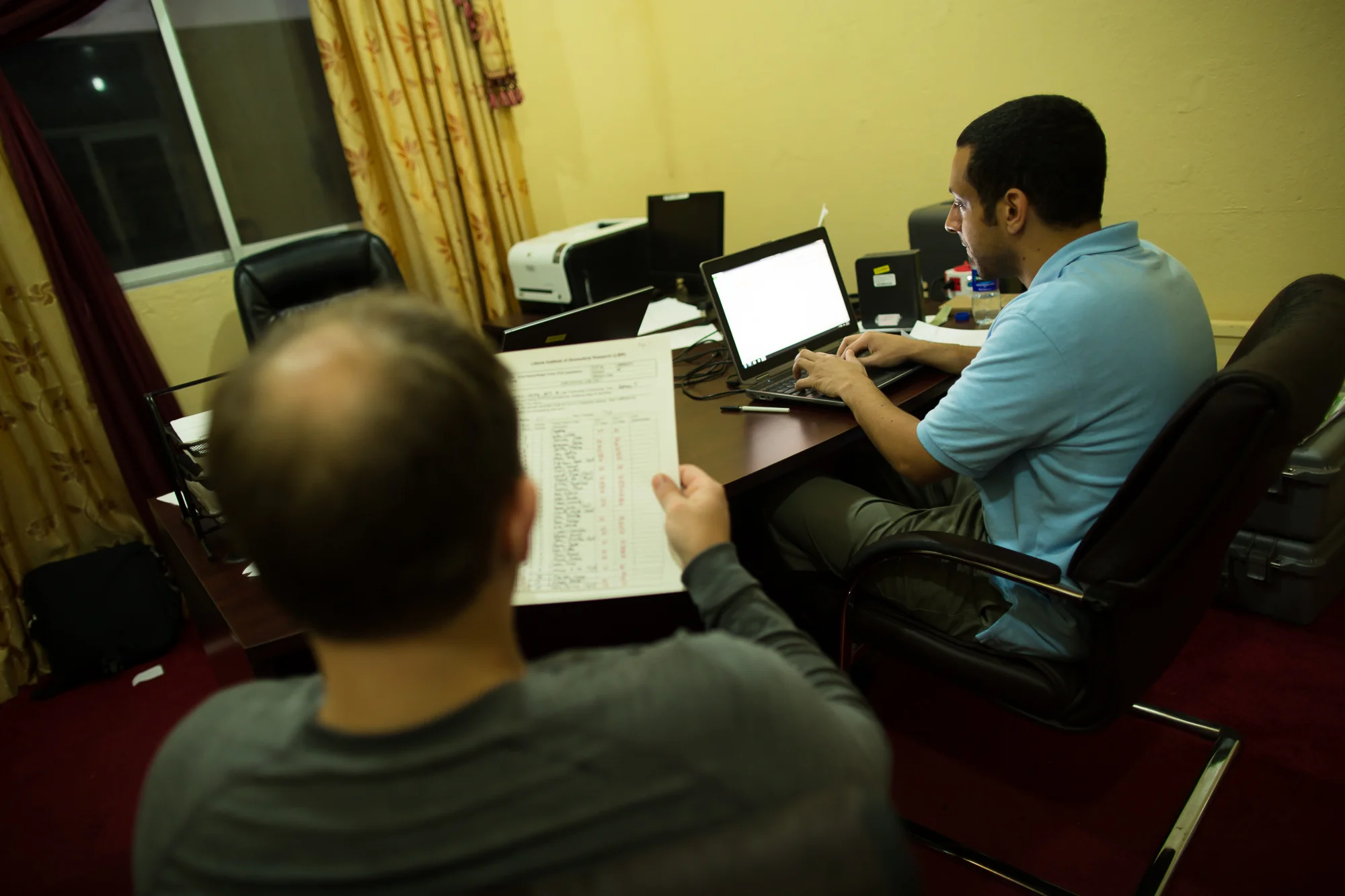  Harbel, Liberia - September 26, 2014: Dr. Jason Kindrachuk (left) and Microbiologist, Dr. Anthony Jones (right) spend four to eight hours of their day in protective space-like suits in a laboratory containment suite preparing samples from potential 