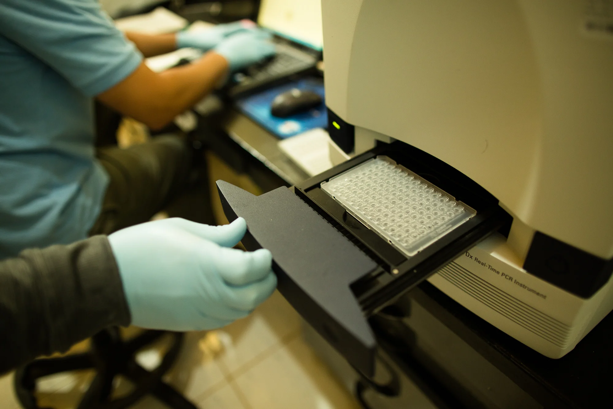  Harbel, Liberia - September 26, 2014: Dr. Jason Kindrachuck inserts the DNA from 47 people&nbsp;into a P olymerase Chain Reaction &nbsp;(PCR) machine to determine if they test positive for Ebola. This machine can test up to 100 samples of human DNA 