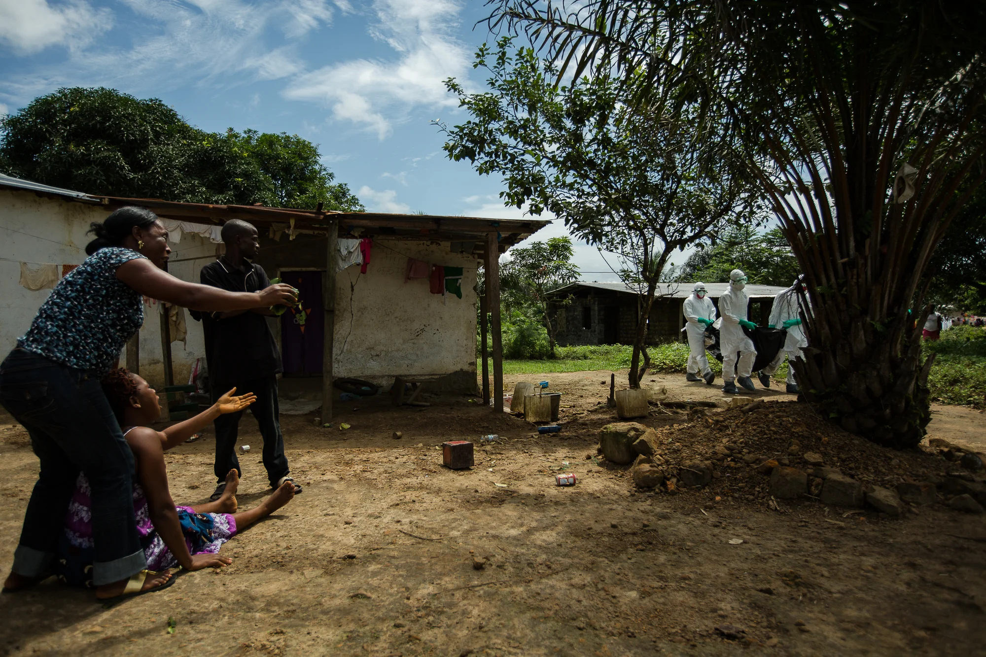  Monrovia, Liberia - September 26, 2014: Neighbors grieve as Assistant Team Leader, Melvin Payoh,&nbsp;and his burial team from Global Communities collect the body of a woman suspected to have died of Ebola. Photo by Morgana Wingard 