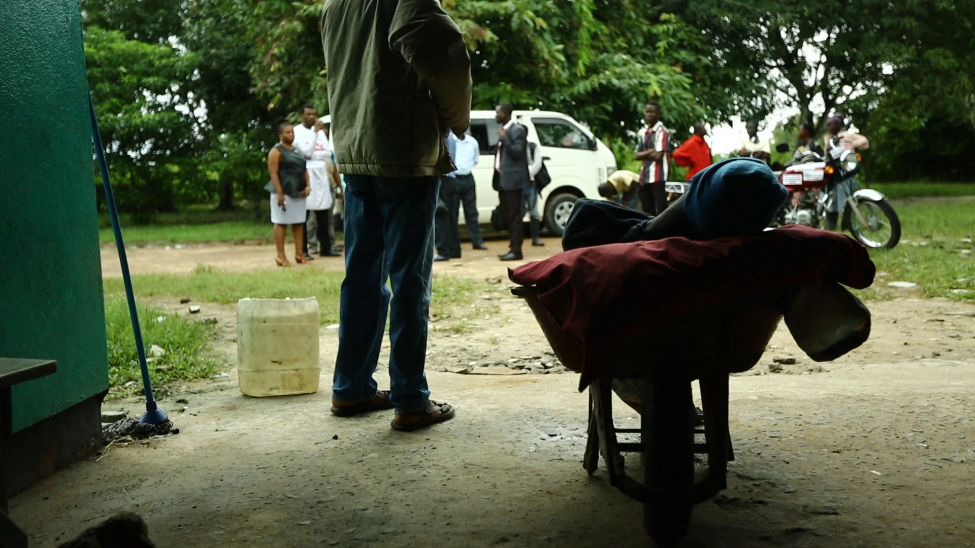  Dola Town, Liberia - Sept 1, 2014: &nbsp;A father brings his son to the clinic in Dola Town in a wheelbarrow because he is too weak to walk. He called the Ebola hotline and ambulances, but no one will pick him up because all the Ebola treatment cent