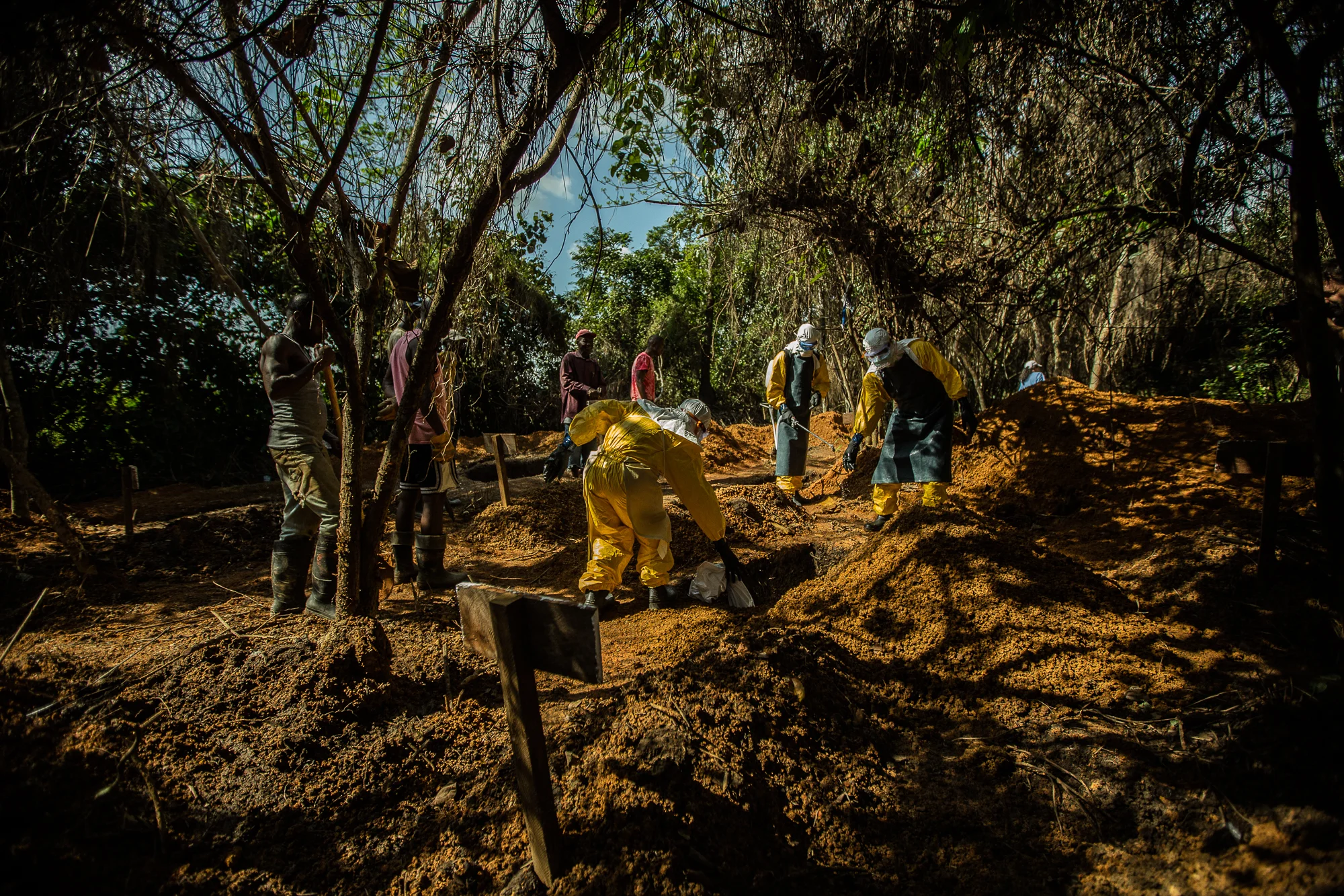  Bong County, Liberia - October 8, 2014: A burial team at the International Medical Corps Ebola treatment unit lower a body from an Ebola patient into a grave in their graveyard built behind the clinic.&nbsp;Photo by Morgana Wingard 