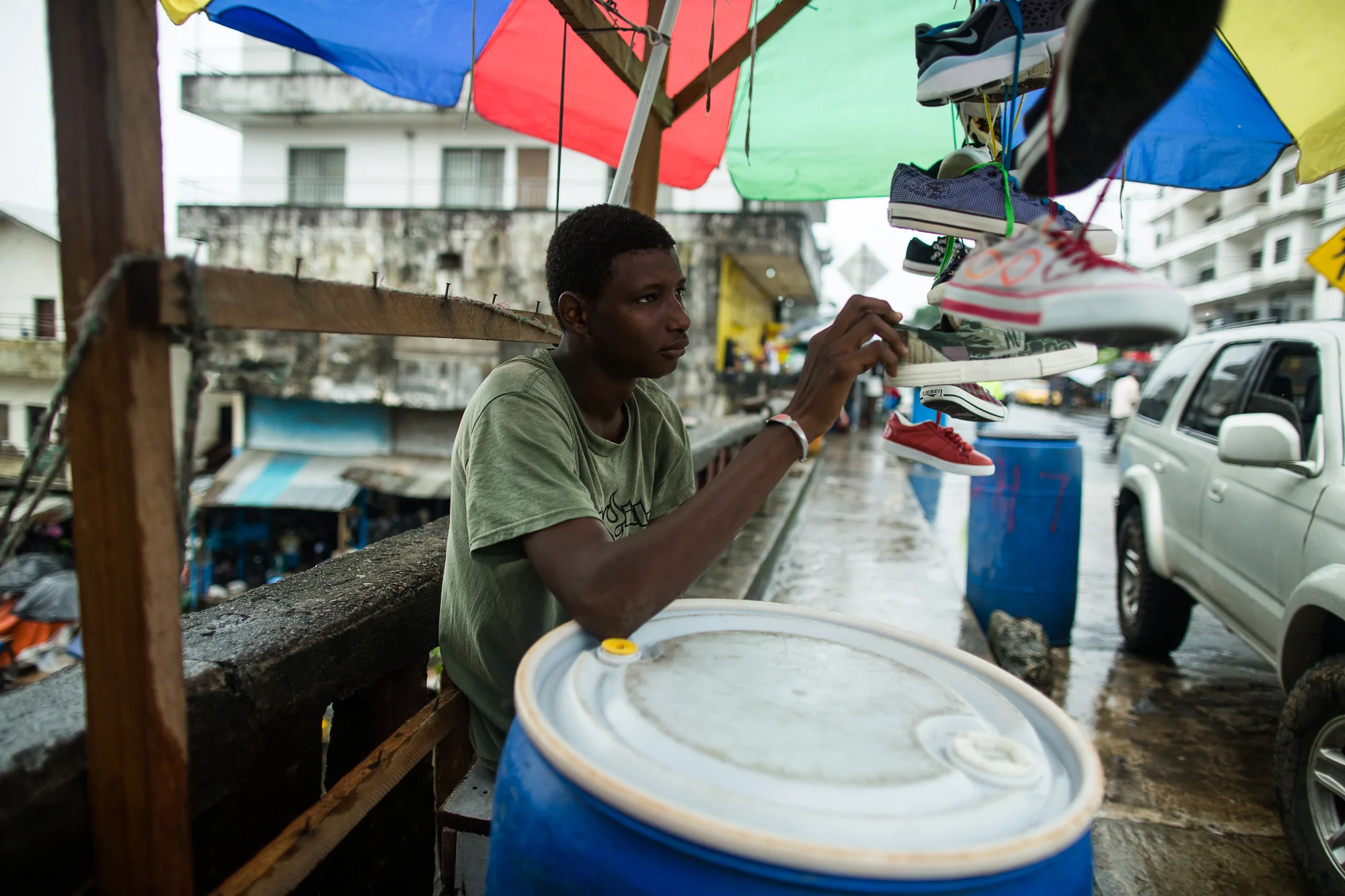  Monrovia, Liberia - September 18, 2014: &nbsp;Ibrahim (20)&nbsp;and Edmond (30) sell shoes in Waterside Market in downtown Monrovia. Normally at this time of year they are selling shoes for students going back to school. On a typical day they would 