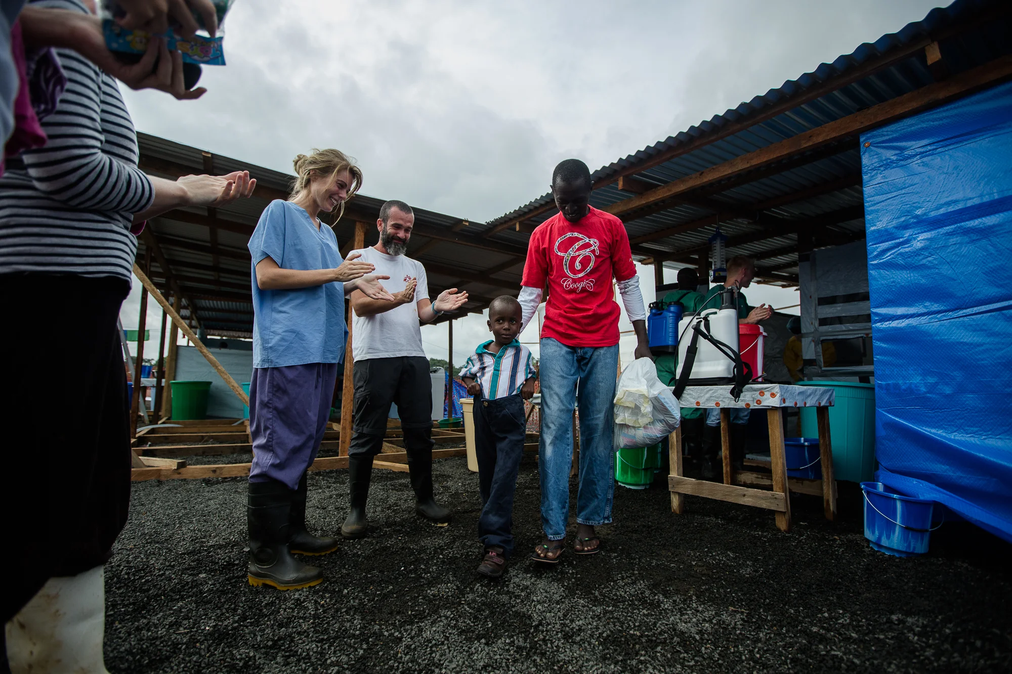  Monrovia, Liberia - Aug 31, 2014: William Poopei (40)&nbsp;and Patrick Poopei (6)&nbsp;walk out of the isolation unit at ELWA 3 —  the Ebola treatment unit&nbsp;run by Doctors Without Borders (MSF). &nbsp;William and Patrick (father and son) are bot