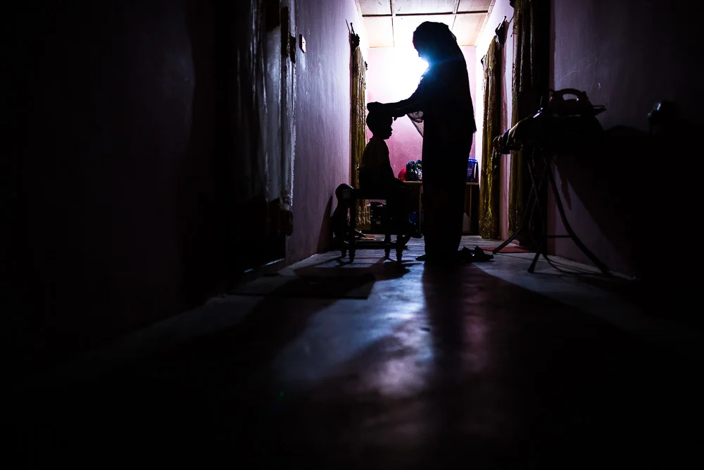  After morning prayers, Habiba helps her two boys get ready for school. 